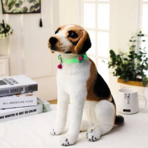 כלב מפוחלץ עם קולר זוהר בחושך יושב על מיטה.